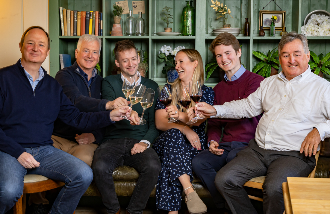 Ellis Family sitting together toasting with wine glasses