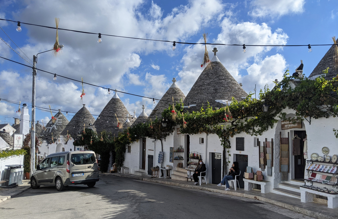 Row of white houses with conical tiled rooves