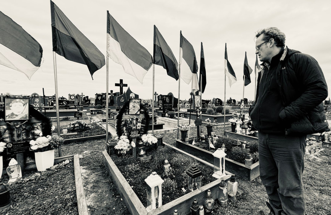 Richard Yates overlooking cemetery with Ukranian flags