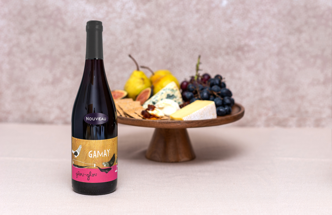 Bottle of Glou-Glou Gamay infront of a cheeseboard