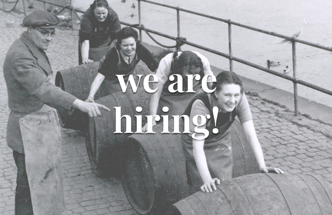 Historic black and white picture of women pushing wine barrels