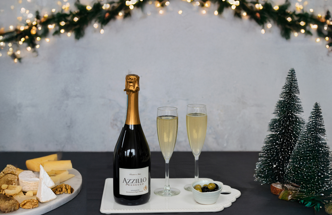 Bottle of Azillo Prosecco with flutes and decorative Christmas trees