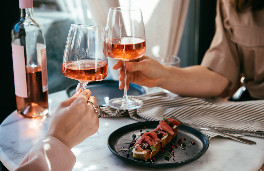 Cheers with two glasses of rosé wine