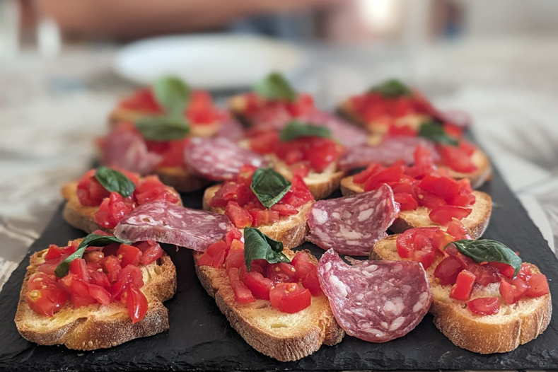 Bruschetta and salami on slate board