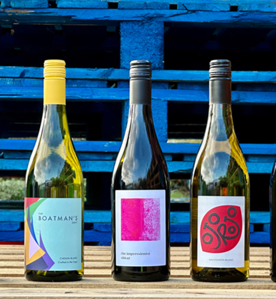 Five wine bottles lined up on wooden crate
