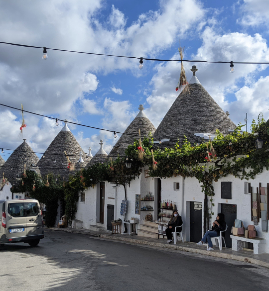 Row of white houses with conical tiled rooves