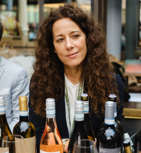 Roberta Bricolo standing behind counter of wine bottles
