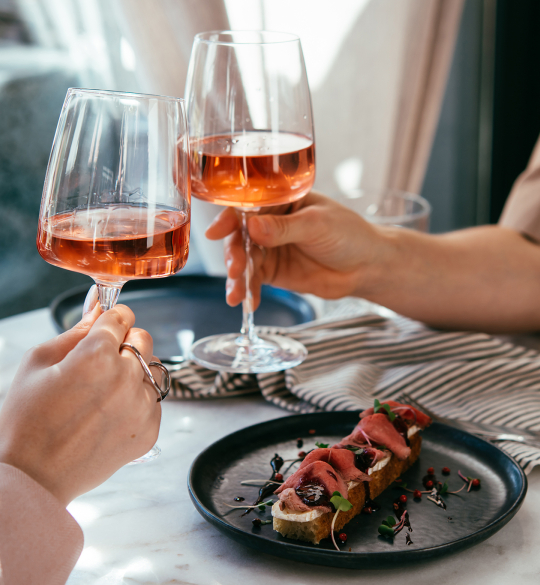 Cheers with two glasses of rosé wine