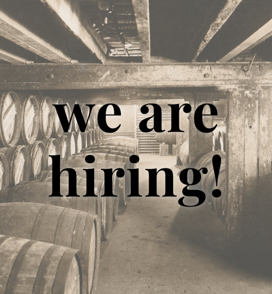 Barrels in cellar with overlay text: we are hiring